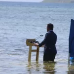 Ministro de Tuvalu, Simon Kofe, grava discurso para COP26 (2021) de dentro do mar em protesto pelo afundamento da ilha (Foto Reprodução G1)