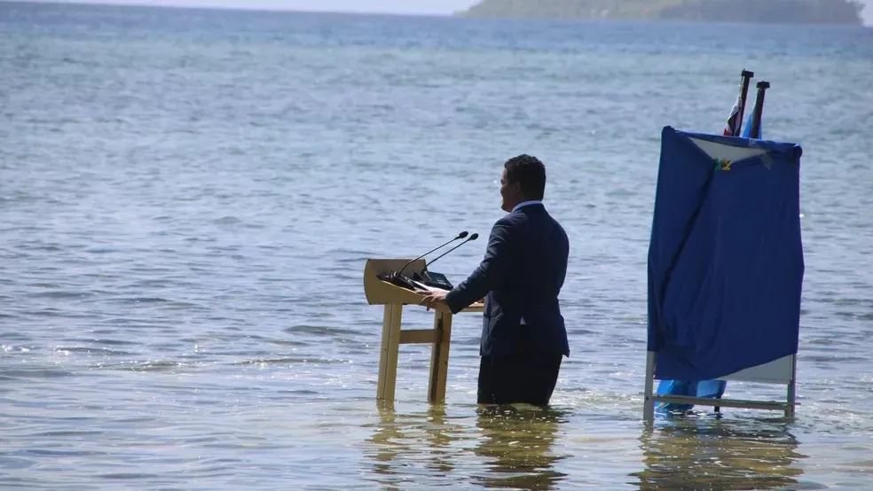 Ministro de Tuvalu, Simon Kofe, grava discurso para COP26 (2021) de dentro do mar em protesto pelo afundamento da ilha (Foto Reprodução G1)