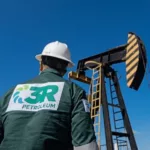 Trabalhador da 3R Petroleum em frente a cavalo-de-pau para a produ&ccedil;&atilde;o terrestre de petr&oacute;leo (Foto Divulga&ccedil;&atilde;o)