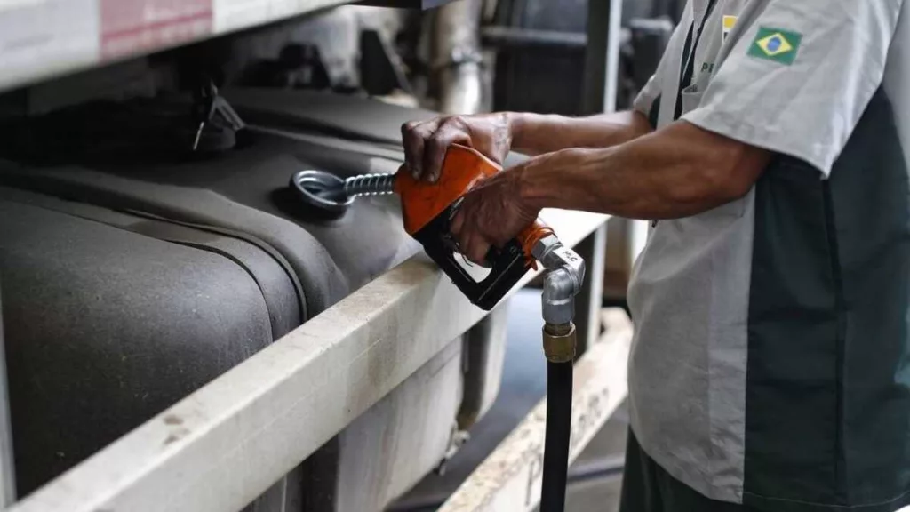 Mão de frentista segura gatilho e abastece tanque de caminhão a diesel em posto da Petrobras (Foto Divulgação Scania)
