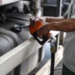 Mão de frentista segura gatilho e abastece tanque de caminhão a diesel em posto da Petrobras (Foto Divulgação Scania)