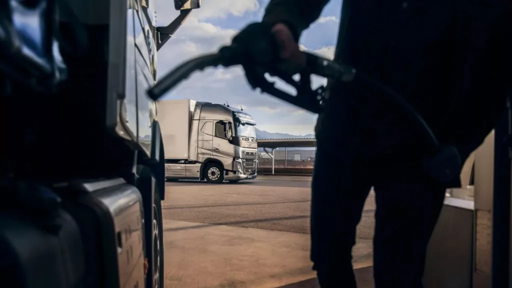 Foto à contraluz de frentista abastecendo caminhão com óleo diesel (Foto: Divulgação Volvo)
