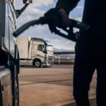 Foto à contraluz de frentista abastecendo caminhão com óleo diesel (Foto: Divulgação Volvo)