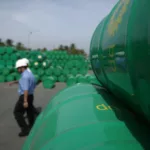 Trabalhadores em estoques de barris de petróleo, na cor verde, no Reino Unido (Foto Divulgação BP)