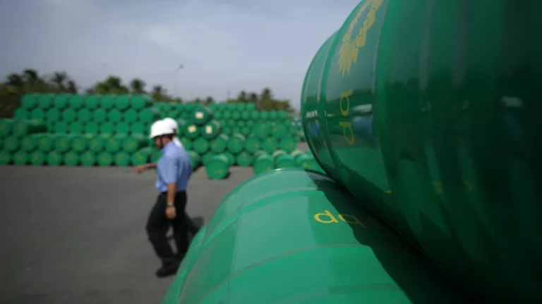 Trabalhadores em estoques de barris de petróleo, na cor verde, no Reino Unido (Foto Divulgação BP)