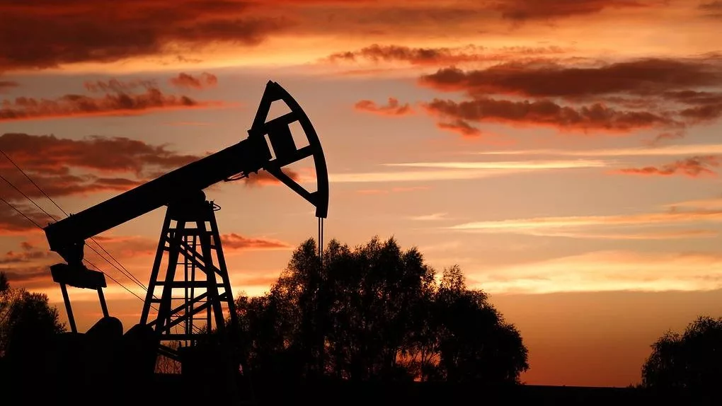Cavalos-de-pau (bombas pumpjacks) para produção de petróleo onshore na Rússia e, ao fundo, céu alaranjado (Foto Yegor Aleyev/TASS)