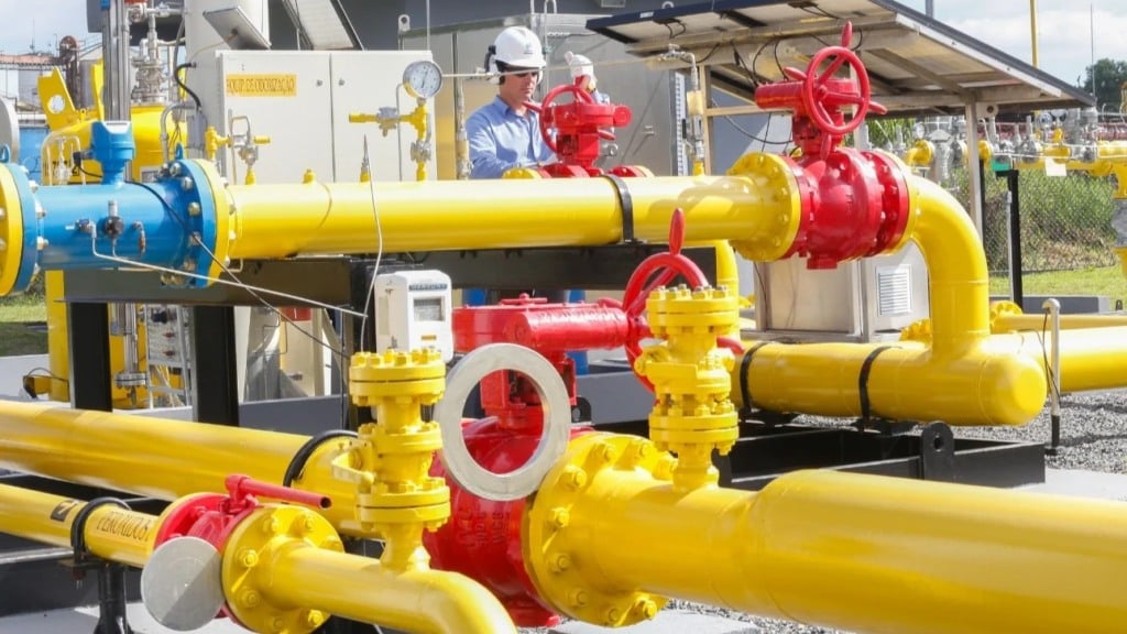 Citygate (ponto de entrega de gás) da Compagas, distribuidora de gás natural do Paraná; Rede de gasodutos nas cores amarela e vermelha, com trabalhador realizando inspeção; veste uniforme azul e capacete branco (Foto Divulgação)