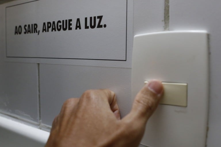 Interruptor de energia elétrica ao lado do recado por escrito 'Ao sair, apague a luz.' (Foto Fernando Frazão/Agência Brasil)