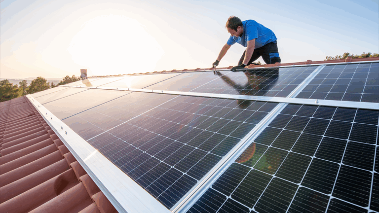 Técnico instala painéis solares fotovoltaicos sobre telhado residencial