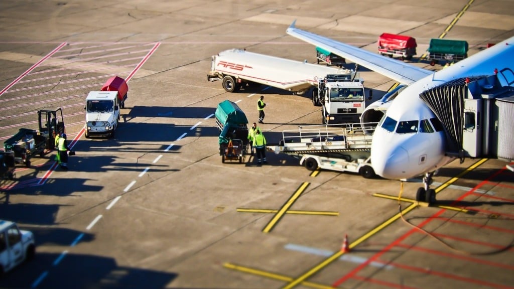 Foto aérea de avião sendo abastecido em aeroporto, com caminhões-tanque e trabalhadores próximos à aeronave (Foto Divulgação)