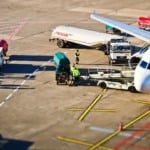 Foto aérea de avião sendo abastecido em aeroporto, com caminhões-tanque e trabalhadores próximos à aeronave (Foto Divulgação)
