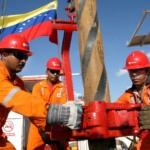 Funcion&aacute;rios da PDVSA, petroleira estatal da Venezuela, operam equipamento de perfura&ccedil;&atilde;o; uniformizados, em laranja, com equipamentos e sinaliza&ccedil;&otilde;es de seguran&ccedil;a e capacete vermelho (Foto Divulga&ccedil;&atilde;o)